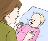 Eine erwachsene Frau kitzelt ein Baby.